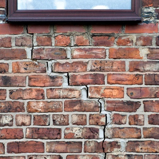 step cracking damage to brickwork in a wall beneath a window as a result of subsidence